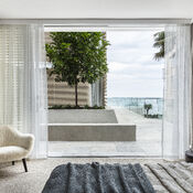 Looking out to a oceanfront patio from a bedroom at Bower.