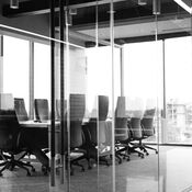 A boardroom of a modern office building with large floor-to-ceiling windows overlooking the city