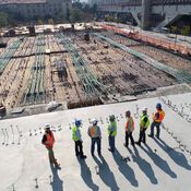 A row of people wearing hardhats overlooking a construction site