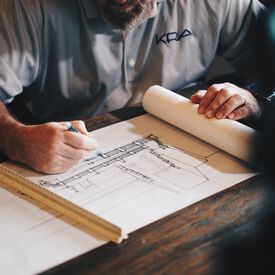 A person drawing construction blueprints